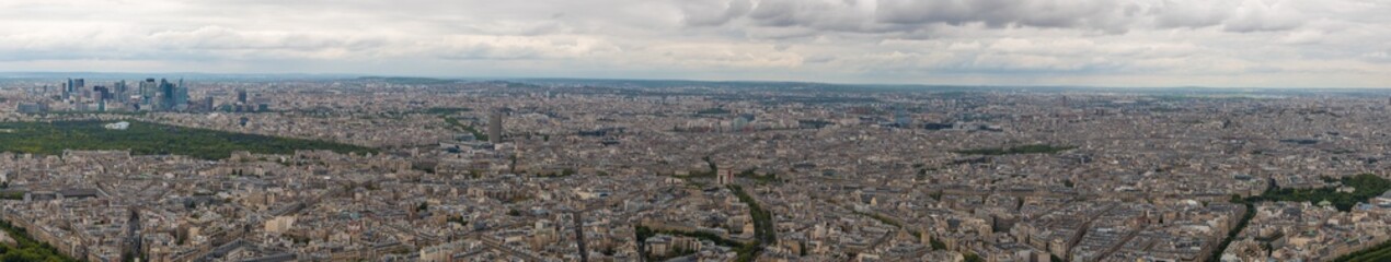 Fototapeta na wymiar Huge aerial panorama photo of the 16th & 17th arrondissement of Paris with Arc de Triomphe in the centre. On the left side the Bois de Boulogne park and the business district La Défense can be seen.