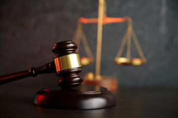 Judge gavel, scales of justice and law books in court