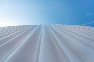Low angle view of exterior detail of undulating opaque white transparent acrylic glass facade...