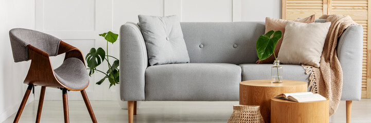 Panoramic view of modern interior with gray sofa and chair