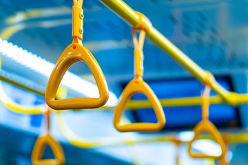 Passenger transport interior. Handrails on the ceiling bracket in the bus. Hanging transport...