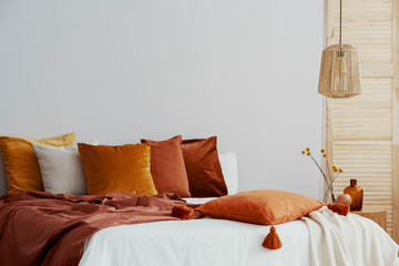 Closeup of pillows and blanket on cozy bed with white duvet