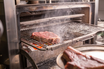 food, craft and delicious concept - cooking steak on a grill