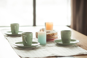 Table with cups and plates on rustic background. Loft interior.