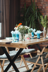 Table with cups and plates on rustic background. Loft interior.