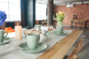 Table with cups and plates on rustic background. Loft interior.