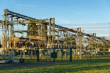 Fototapeta na wymiar electric power line in a field - voltage transformation substation