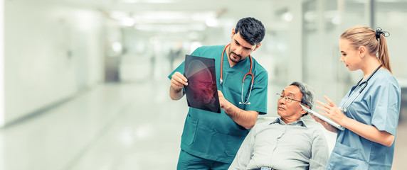 Surgeon showing xray film to senior patient looking at brain injuries with nurse standing beside the surgeon at the hospital room. Medical healthcare and surgical doctor service concept.