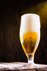 Cold beer into a glass with  foam.