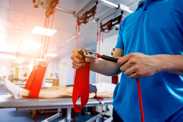 Physiotherapy. Suspension training therapy. Young man doing fitness traction therapy with suspension-based exercise training system.