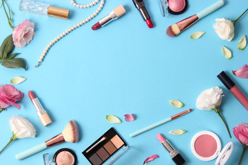 cosmetics and flowers on a colored background top view.