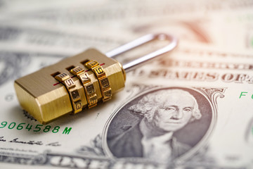 Golden security digital password lock key on US dollar banknotes.  