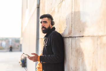 Young Hipster Man Listening Music on Headphones.