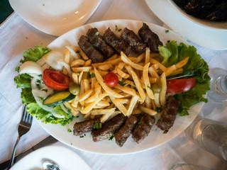 Fried small meat cutlet on white ceramic plate top view