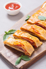 Pizza roll stromboli with cheese salami olives and tomatoes