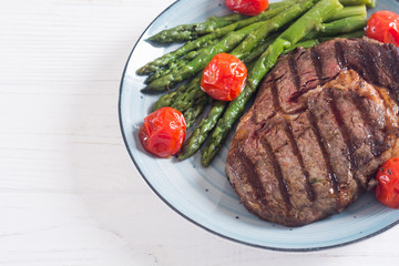 Grilled beef steak ribeye with cherry tomatoes and asparagus