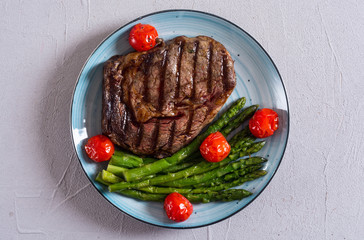 Grilled beef steak ribeye with cherry tomatoes and asparagus