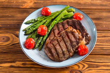 Grilled beef steak ribeye with cherry tomatoes and asparagus