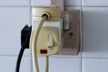 Household multi plug overloaded with old plugs. UK 3 pin plug, old with paint peeling 