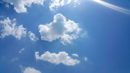 beautiful background of clouds, clearly visible lines of white clouds and blue sky, the top is a sunbeam