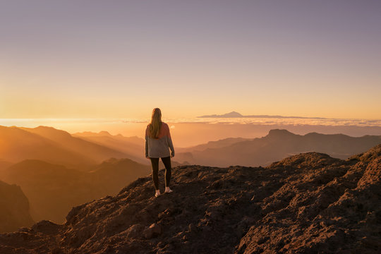 Happy young woman standing and enjoying life at sunset in mountains - gran canaria, spain