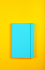 Blue leather cover notebook over yellow