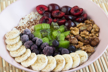 Oatmeal with banana, cherries, kiwi, blueberries, walnuts