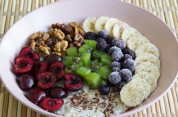 Oatmeal with banana, cherries, kiwi, blueberries, walnuts