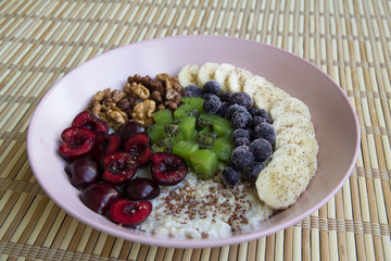 Oatmeal with banana, cherries, kiwi, blueberries, walnuts