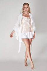 Pretty woman beautiful face bright makeup long blond hair fashion model wear trend clothes for date party summer walk travel cruise collection organic silk cotton dress accessory jewelry white studio.