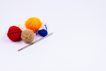 Crochet hook and wool - white background.