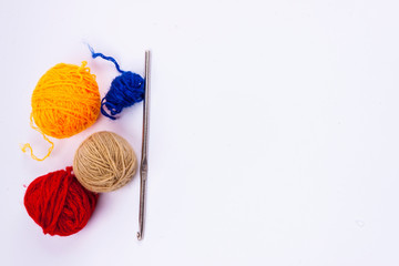 Crochet hook and wool - white background.