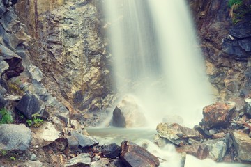 Waterfall outside of skagway alaska, with pine trees and jagged rocks