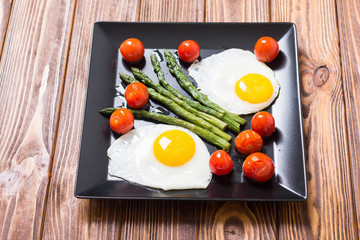 Healthy breakfast with eggs , asparagus and tomatoes