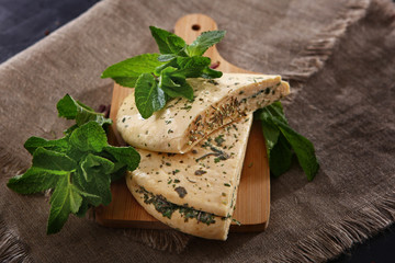 Greek salted Halloumi cheese with mint. Cheese on a wooden background with mint leaves. The concept of homemade cheese making.