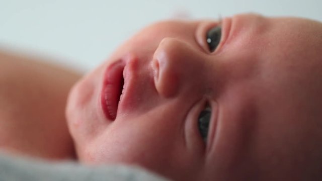 Closeup of newborn baby infant face maco looking and observing
