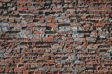 Old brick wall texture. The wall, made of old red bricks, darkened by old age. Ancient vintage brick wall background. Brick wall backdrop