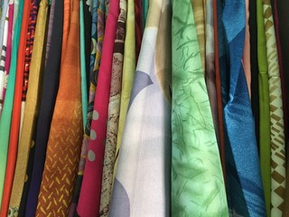 Colorful fabric cotton rolls lined up for the fashion collection,Concept: Clothing product industry for the shop in the market,Sample costume department selling colorful and colorful t-shirts