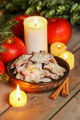 Vintage wooden bowl of gingerbread cookies on christmas eve table.
