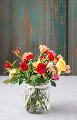 Bouquet of colorful roses in glass vase.