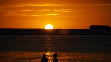 ハワイの夕日と人影と船