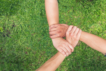 Authentic triangle partners hands together concept. Three hands holding tight promise mission teamwork on green ecosystem business. Customer make triangle three hands of trust to promise unified team