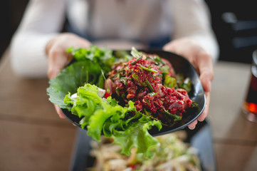 Hand and fresh meat, food of people who like to eat fresh meat, raw food, eating food concepts