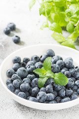 Blueberries in a white bowl on a light background