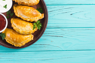 Latin American baked beef empanadas with sauce