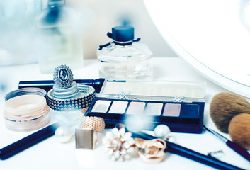 Jewelry table with lot of girl stuff on it, little mess in cosmetic brushes, interior concept closeup