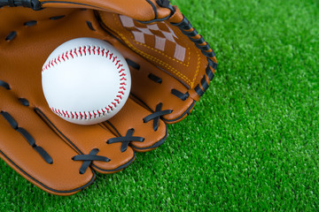 Baseball time. Glove and ball on green grass