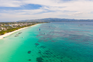 Fototapeta na wymiar White beach on the island of Boracay, Philippines, top view. White sandy beach and turquoise sea water in sunny weather. Residential development and many hotels in Boracay.