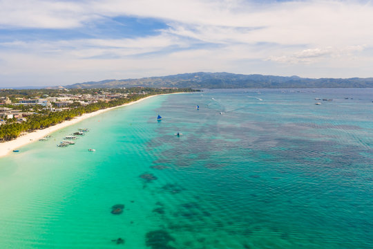 White beach on the island of Boracay, Philippines, top view. White sandy beach and turquoise sea water in sunny weather. Residential development and many hotels in Boracay.
