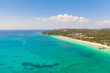 The coast of the island of Boracay. White beach and clear sea. Seascape with a beautiful coast in sunny weather. Residential neighborhoods and hotels on the island of Boracay, Philippines, view from